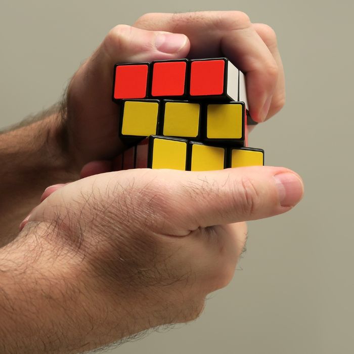 hands solving a rubiks cube